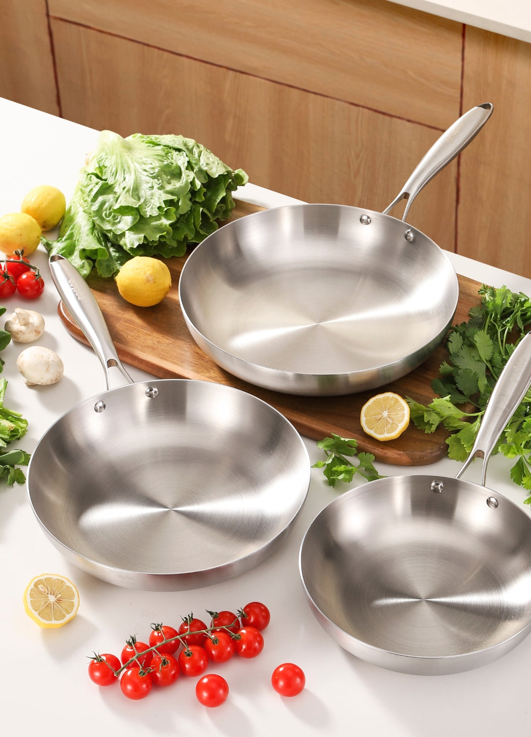 Pack de trois poêles inox Poeleo 22, 26 et 28 cm sur plan de travail